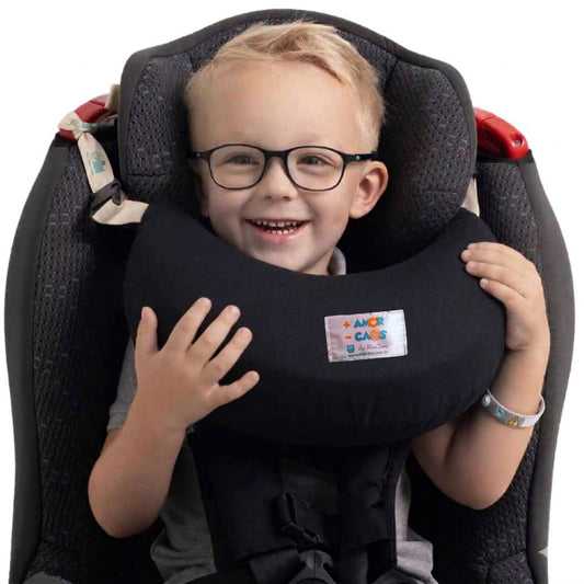 Criança dormindo confortavelmente no carro usando a almofada de pescoço Nanadini da MiniDini
