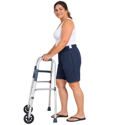 Mulher em pé apoiada em um andador, vestindo a bermuda adaptada azul marinho.