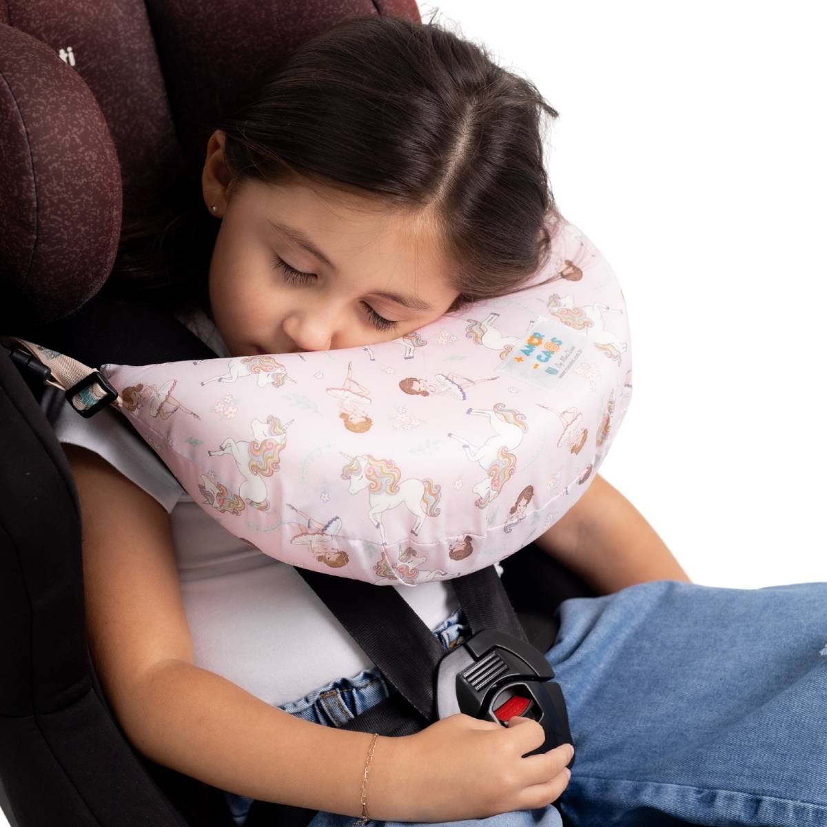 Menina maior dormindo confortavelmente na cadeirinha apoiada na almofada Nanadini rosa unicórnios — suporte cervical para crianças de todas as idades